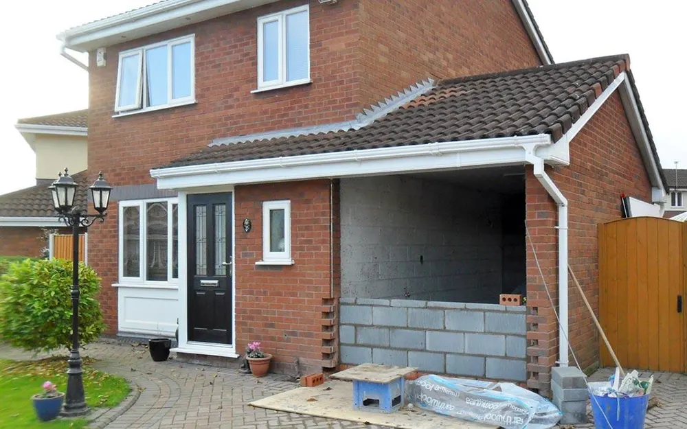Single-storey side extension in blockwork next to a brick house